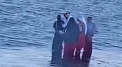 A group dressed in unusual red, black and white attire spotted carrying chickens along Diani Beach. PHOTO/ SCREENGRAB.