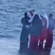 A group dressed in unusual red, black and white attire spotted carrying chickens along Diani Beach. PHOTO/ SCREENGRAB.