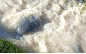 A photo of spilled chemical flowing down a river.
