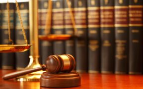 The Image Depicts a Legal Eetting, Featuring a Wooden Gavel and a Scale of Justice in the Foreground, with a Row of Law Books in the Background. PHOTO/ Courtesy