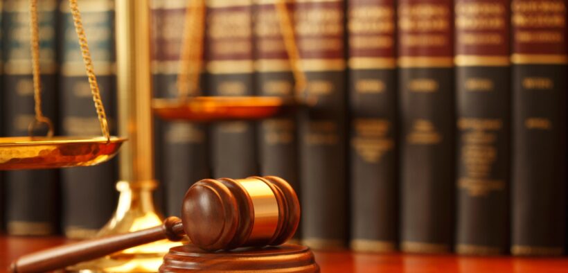 The Image Depicts a Legal Eetting, Featuring a Wooden Gavel and a Scale of Justice in the Foreground, with a Row of Law Books in the Background. PHOTO/ Courtesy