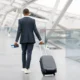 Black Man In Suit Walking With Suitcase At Airport Terminal. PHOTO/ Courtesy