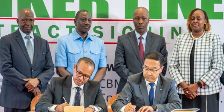 Amsons Group Managing Director, Mr Edha Nahdi (foreground left) and Sinoma CBMI Chairman, Mr Zhang Sicai (fore right), signing the US$250 million Matuga Clinker Factory Construction contract, witnessed by President William Ruto, Bamburi Cement Plc Chairman John Simba, MITI CS Lee Kinyanjui and Bamburi Cement Head of Legal and Company Secretary Joyce Munene.
