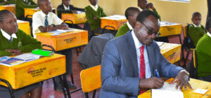 Education CS Julius Ogambo sitting in a classroom. PHOTO/NA