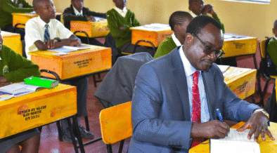Education CS Julius Ogambo sitting in a classroom. PHOTO/NA