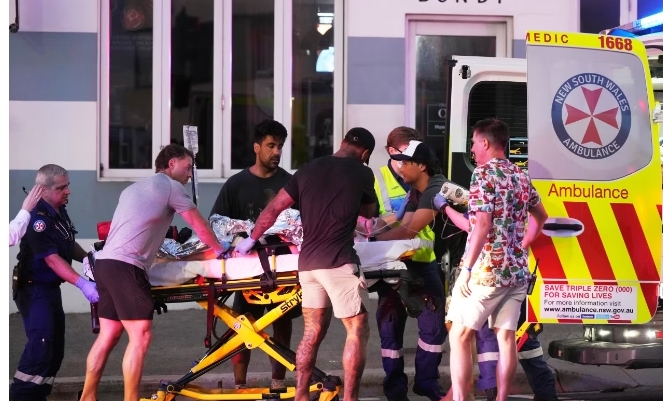 Emergency workers transport a person on a stretcher after a reported shooting at Bondi Beach in Sydney on December 14, 2025