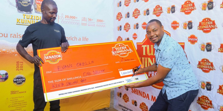 The image shows the Senator Keg Tuzidi Kuinuana Promotion award winner Evans Okello receiving his grand prize Image/Tuzidi Kuinuana Promotion