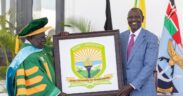 Bomet University Chancellor receiving the schoool logo from the president during the a ward of charter ceremony on February 3, 2025 at the State House. PHOTO/@EduMinKenya/X