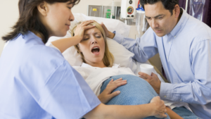 A woman on a maternity bed being consoled by nurses just before delivery. PHOTO/ Shutterstock