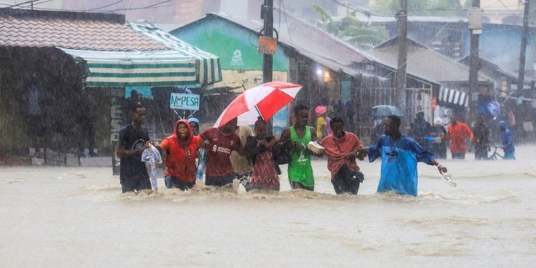 The image shows people moving in floods as most parts of the country keep receiving heavy rains PHOTO/File