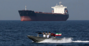 A small Iranian Naval patrol boat cruises past an oil tanker in the Strait of Hormuz canal. PHOTO/ Bloomberg