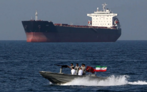 A small Iranian Naval patrol boat cruises past an oil tanker in the Strait of Hormuz canal. PHOTO/ Bloomberg