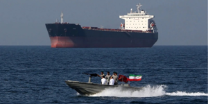 A small Iranian Naval patrol boat cruises past an oil tanker in the Strait of Hormuz canal. PHOTO/ Bloomberg