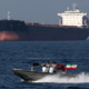 A small Iranian Naval patrol boat cruises past an oil tanker in the Strait of Hormuz canal. PHOTO/ Bloomberg