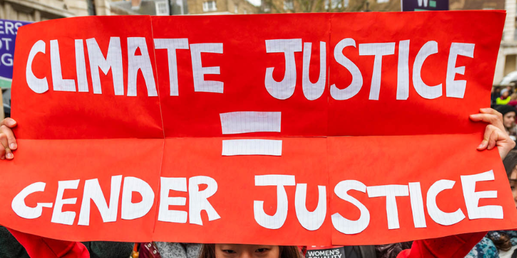 Placard with the words “Gender Justice” and “Climate Justice.” PHOTO/DeSmog.