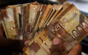 A hand holding Kenyan 1,000-shilling notes