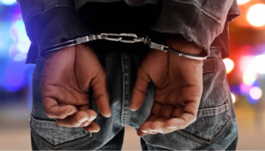 A photo of a man in police handcuffs. PHOTO/ istock images
