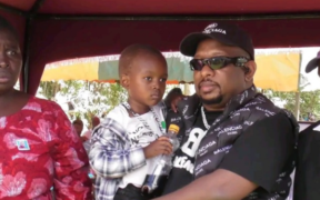 Businessman Mike Sonko holding baby James in company of the James relatives during the burial of his father in Kisii. PHOTO/ File