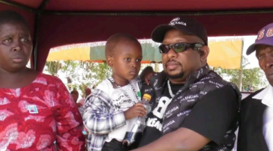 Businessman Mike Sonko holding baby James in company of the James relatives during the burial of his father in Kisii. PHOTO/ File