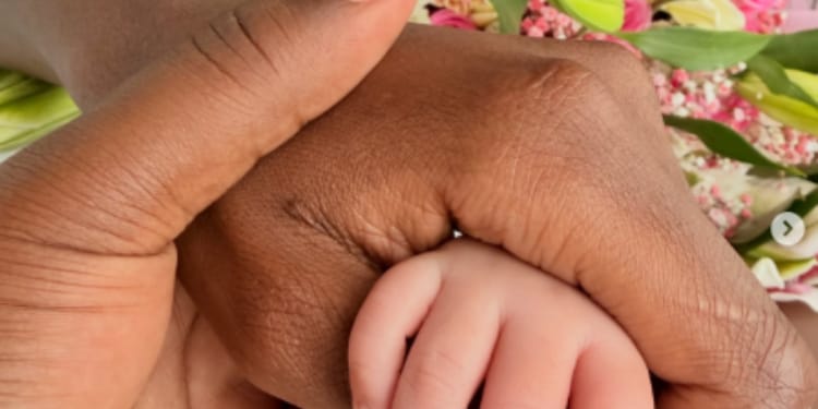 Apicture of Betty Kyalo and Charlie holding their baby's hand
