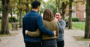 AI Image of a man embracing a woman from behind while another woman stands facing them in tears, creating a dramatic, emotional scene.