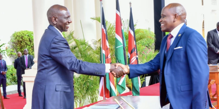Dennis Itumbi shakes President William Ruto's hand