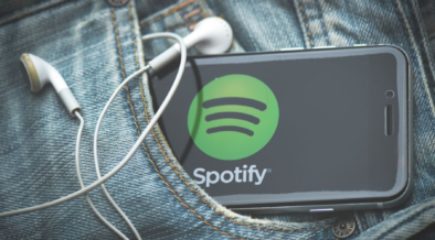 A phone in someone's pocket bearing the logo of Spotify with earphones on it. PHOTO/ File
