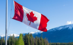 A Canadian flag with a background of Canada landscape. PHOTO/ File