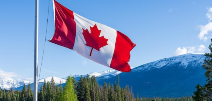 A Canadian flag with a background of Canada landscape. PHOTO/ File