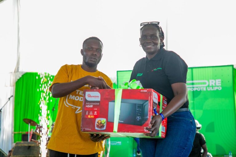 A customer receives a microwave during Safaricom’s PATA MORE campaign launch at Misori Beach, Usenge, Siaya County. Photo/ Safaricom