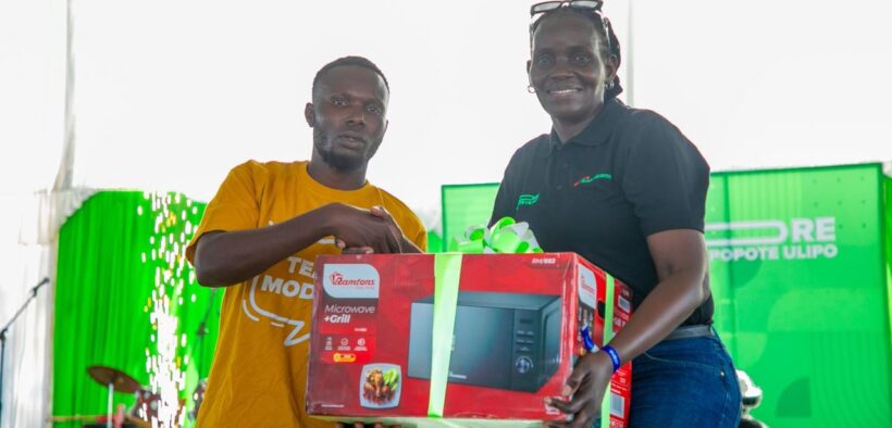 A customer receives a microwave during Safaricom’s PATA MORE campaign launch at Misori Beach, Usenge, Siaya County. Photo/ Safaricom
