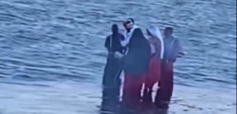 A group dressed in unusual red, black and white attire spotted carrying chickens along Diani Beach. PHOTO/ SCREENGRAB.
