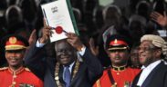 Photo of The Late President Mwai Kibaki lifting a copy of Kenya's new constitution at Uhuru Park in Nairobi on August 27, 2010. PHOTO/ NATION.