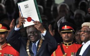 Photo of The Late President Mwai Kibaki lifting a copy of Kenya's new constitution at Uhuru Park in Nairobi on August 27, 2010. PHOTO/ NATION.